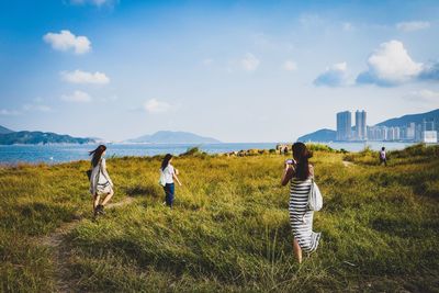 People working on agricultural field against sky