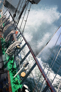 Low angle view of ship sailing in sea against sky