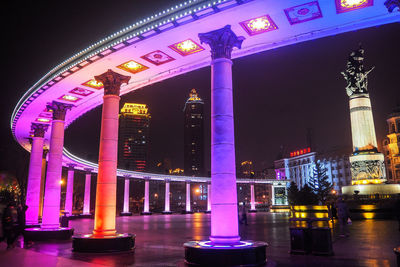 Illuminated bridge in city at night