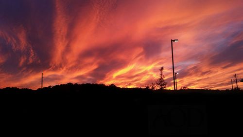 Low angle view of silhouette building against orange sky