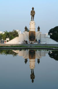 Reflection of historic building in lake against sky