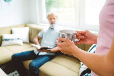 Young woman using mobile phone while sitting on sofa at home