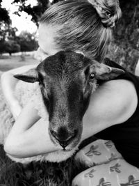 Close-up portrait of dog relaxing on woman