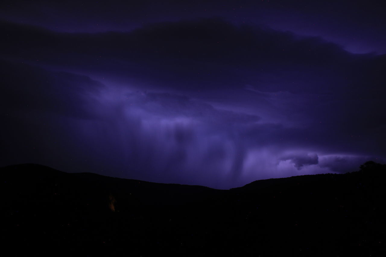 beauty in nature, night, sky, cloud, power in nature, mountain, storm, environment, lightning, thunderstorm, scenics - nature, darkness, dramatic sky, thunder, silhouette, no people, nature, dark, landscape, storm cloud, purple, awe, outdoors, warning sign, mountain range, atmospheric mood