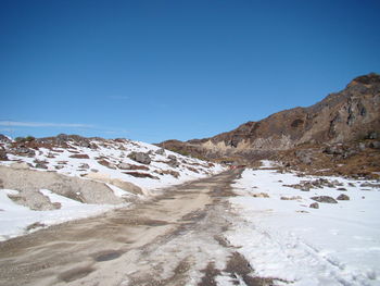 Scenic view of snowcapped mountains against clear blue sky