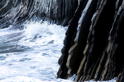 Close-up of rock in sea against sky