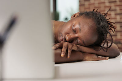 Side view of woman using laptop at home