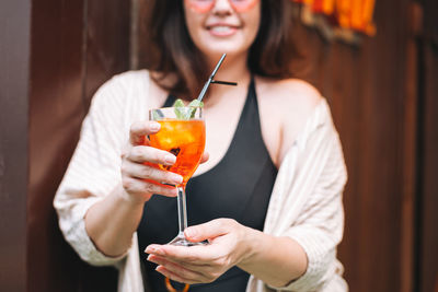 Stylish happy young woman forty years plus size body positive with glass of cocktail