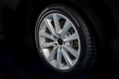 Close-up of car wheel against black background