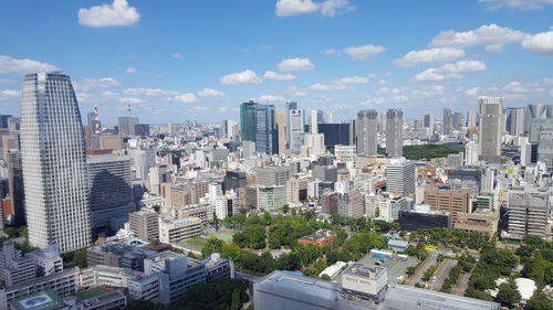 Aerial view of buildings in city against sky