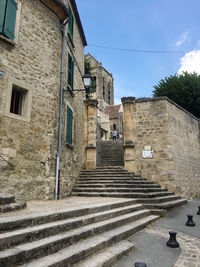 Low angle view of french steps amidst buildings against sky