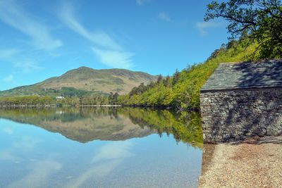 Scenic view of lake and mountains against blue sky