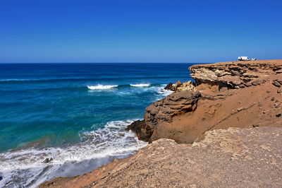 Scenic view of sea against clear blue sky