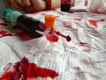 Close-up of artificial blood in syringe on tissue paper