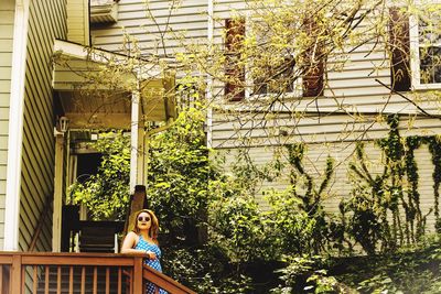 Portrait of young woman against plants