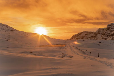 Scenic view of snowcapped mountains against sky during sunset