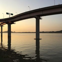 Bridge over river against sky during sunset