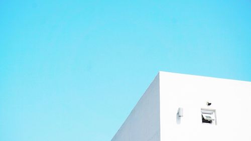 Low angle view of modern building against clear blue sky