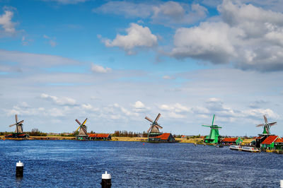 Traditional windmill by sea against sky in the netherlands 