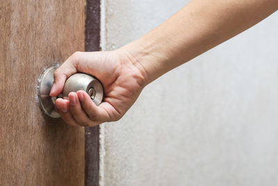 Close-up of hand holding hands against wall