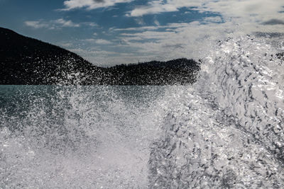 Water splashing in sea against sky