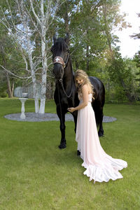 Woman standing by horse at park