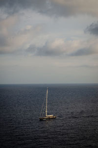 Sailboat sailing on sea against sky