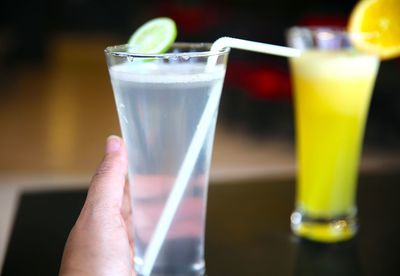 Cropped image of hand holding lemonade at restaurant
