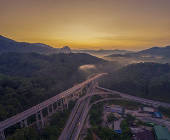 High angle view of bridge over mountains against sky during sunset