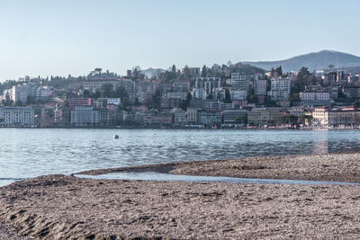 Buildings by sea against sky in city