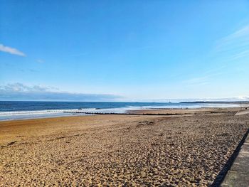 Scenic view of beach against blue sky