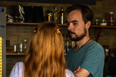 Young couple standing in cozy bar and talking each other