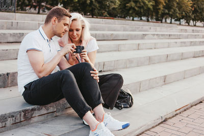 Couple looking at camera while sitting on staircase