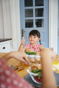 Portrait of cute girl sitting on table