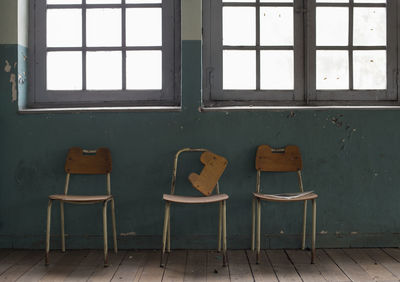 Empty chairs and table in abandoned building