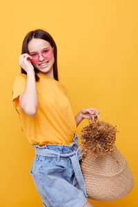 Portrait of smiling teenager against yellow background