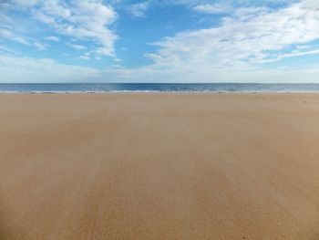 Scenic view of beach against cloudy sky