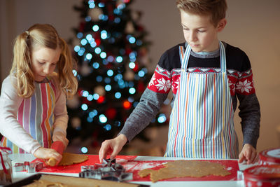 Siblings preparing cookies at home