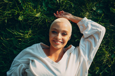 Portrait of smiling young woman lying on field