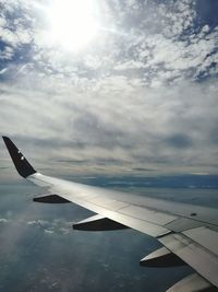 Airplane flying over sea against sky