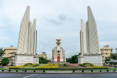 Low angle view of monument against buildings in city