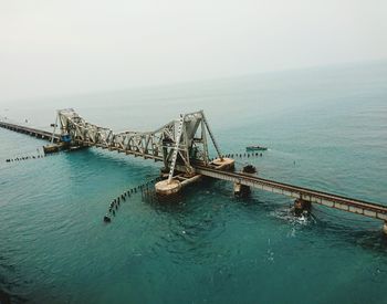 Suspension bridge over sea against sky