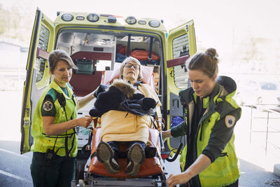 Female paramedics pulling down patient on hospital gurney