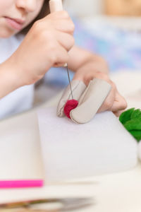 Felt wool craft by handmade needle. little kid girl artisan hand makes creative toy made sheep hair