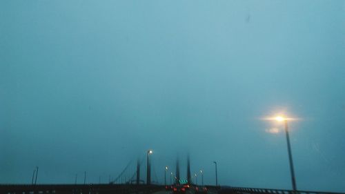 Illuminated street light against sky