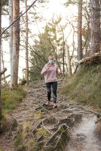 Rear view of woman walking in forest