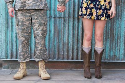 Low section of man and woman standing against corrugated wall