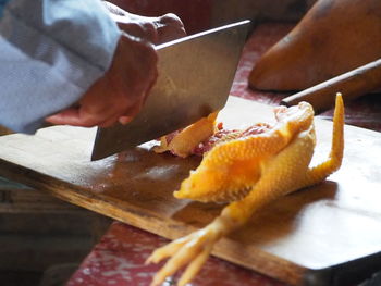 Close-up of hand holding ice cream on table