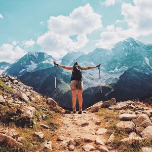 Rear view of backpacker standing against mountains