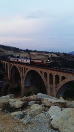 Arch bridge over river against sky